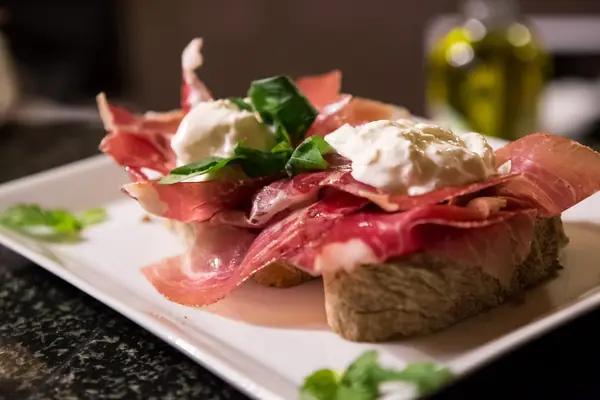 Bruschetta con prosciutto crudo, burrata e basilico – Hosteria il Punto Rosa, Verona